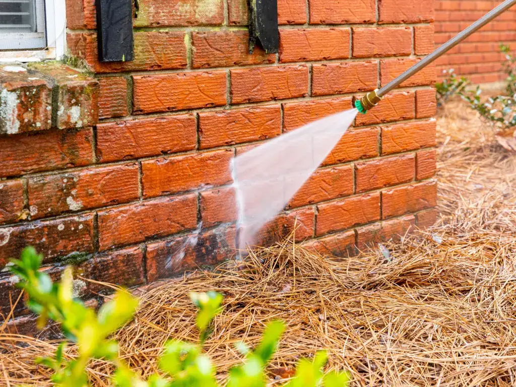 Pressure washing the red brick exterior of a historic home in Mullica Hill, NJ — removing algae, moss, and staining from aged masonry.