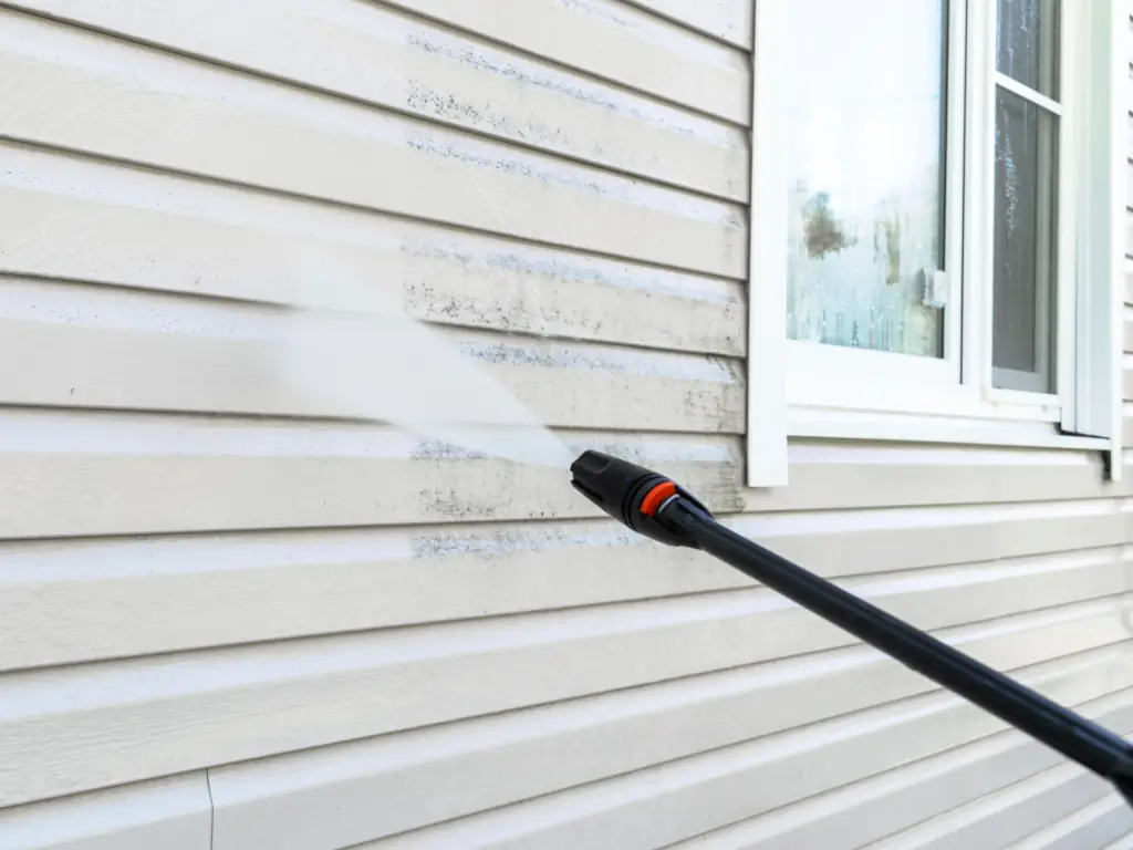 Power washing mold and algae from vinyl siding on a Moorestown, NJ home — removing green and black biological staining from shaded exterior siding panels.