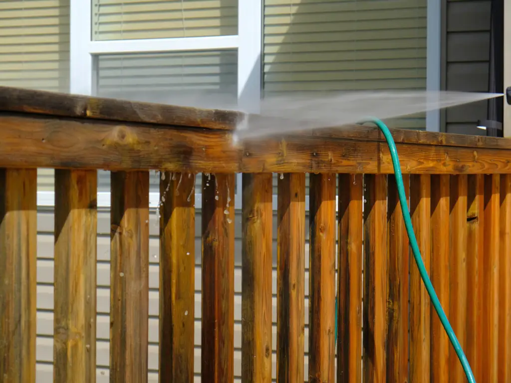 Pressure washing a wood deck and railing on a home in Swedesboro, NJ — removing mildew, dirt, and weathered grime to restore and prep the surface.